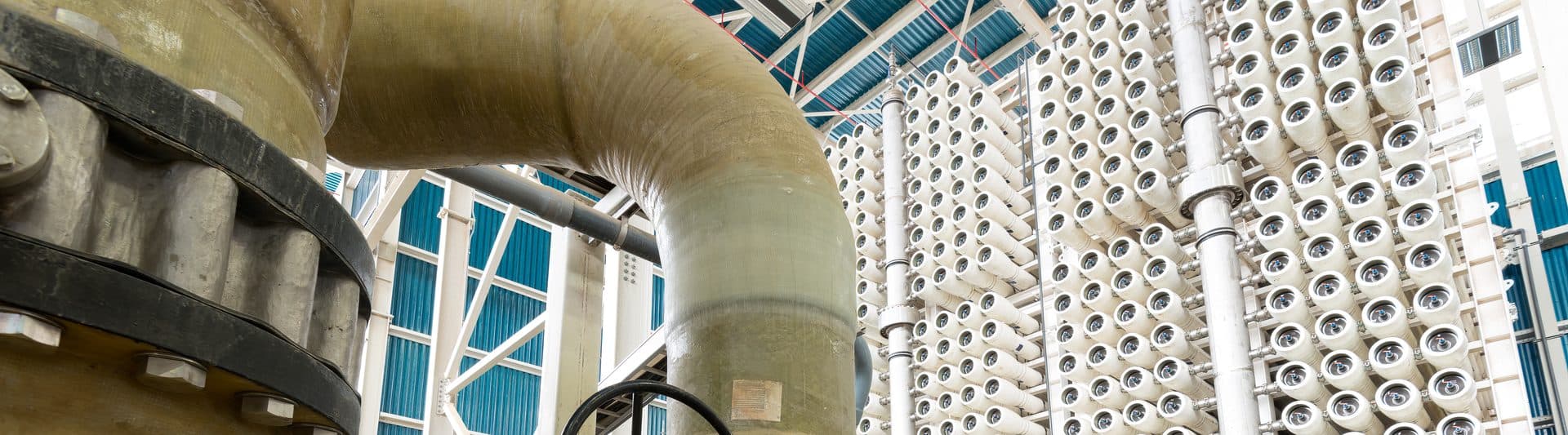 Large valved pipework in front of reverse osmosis membrane racks inside a desalination plant