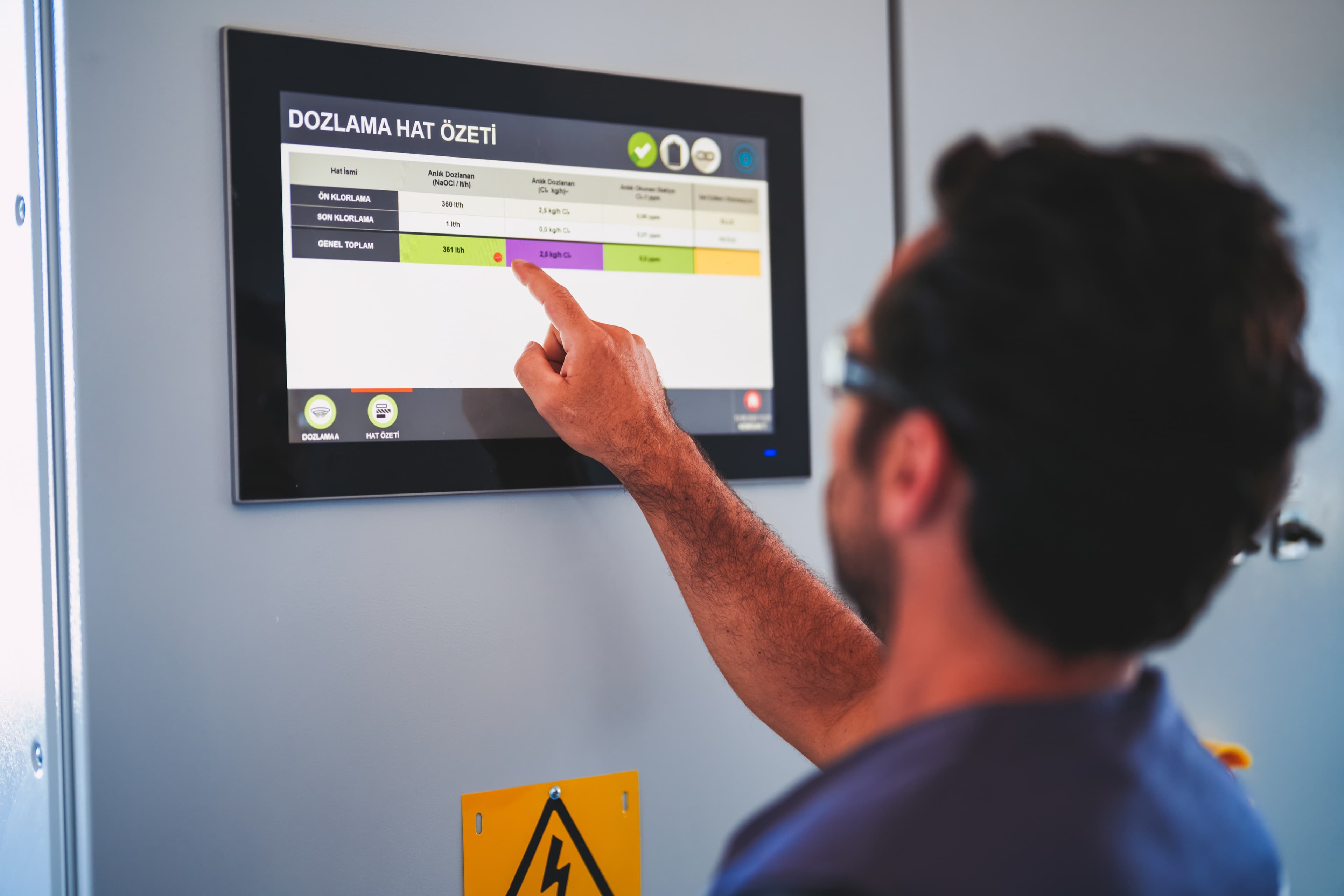 Operator interacting with the HypoX LX dosing line summary screen on the integrated PLC HMI