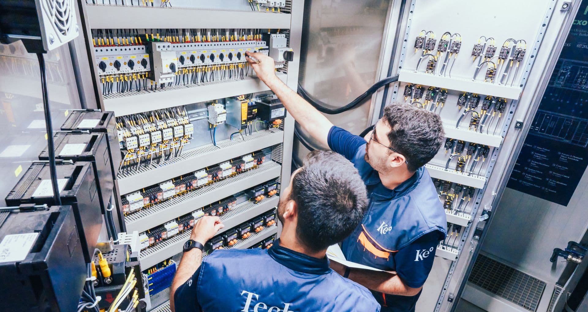 Two Kemisan technicians wiring the electrical panels of the HypoX CX container
