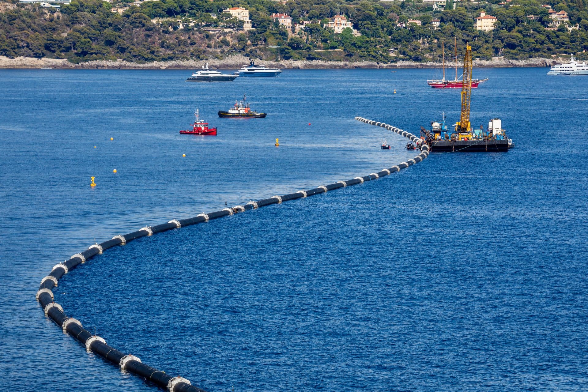 Aerial view of a floating seawater intake pipeline being laid across the sea