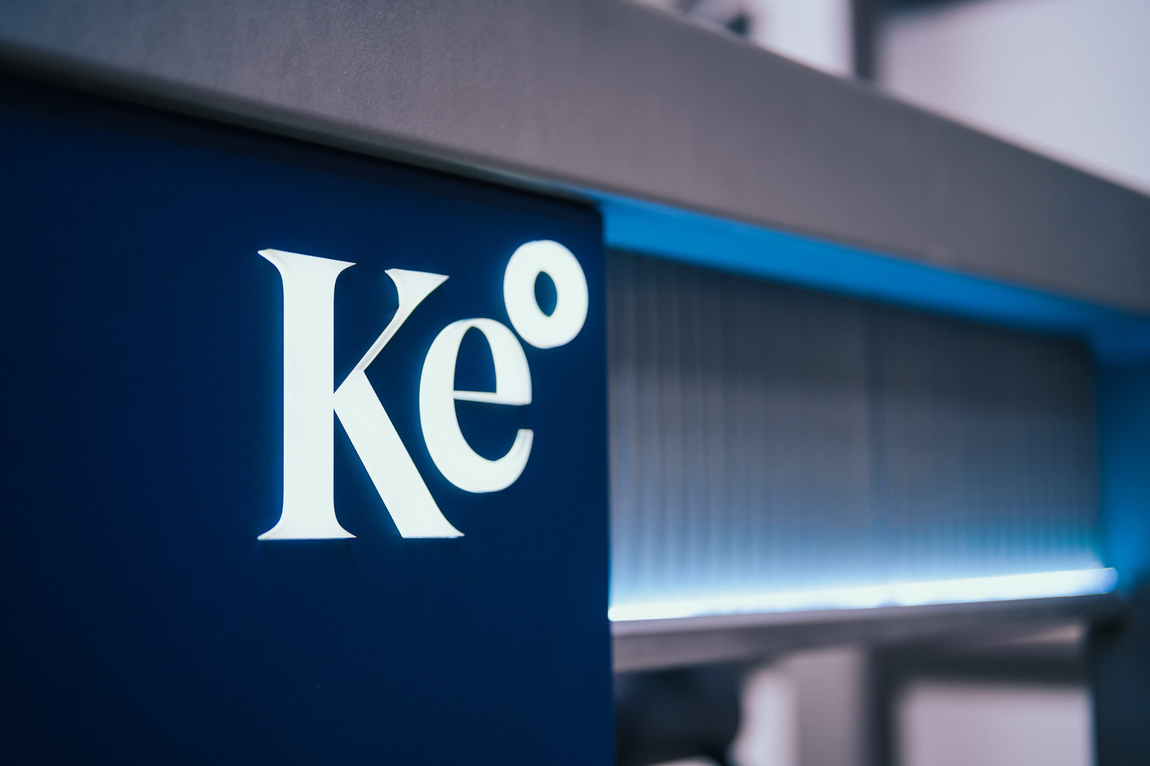Kemisan headquarters building with the Ke logo signage on a deep blue façade