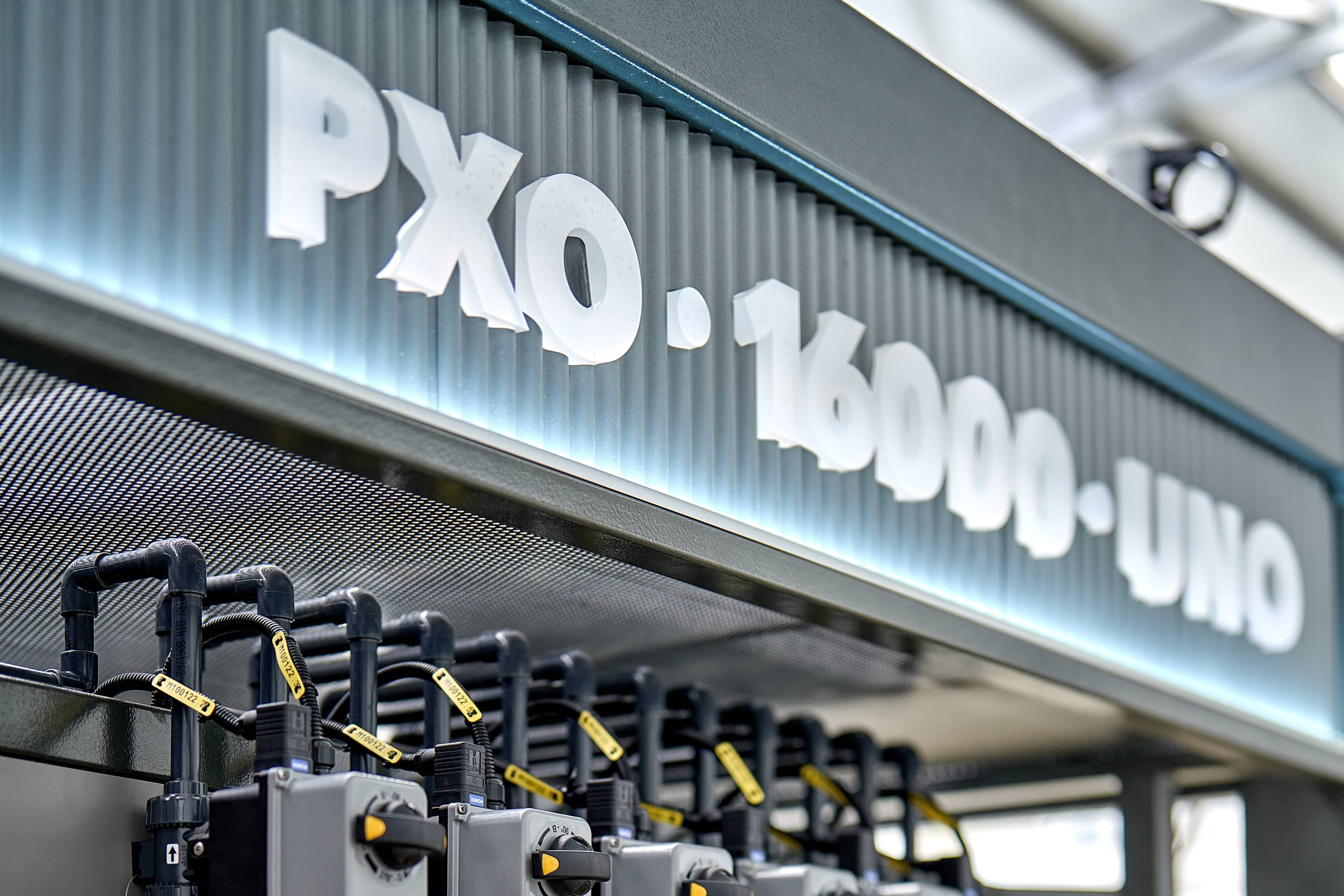 Close-up of an illuminated PXO·16000·UNO branded panel above dosing valves on a HypoX PX skid in a Kemisan production facility